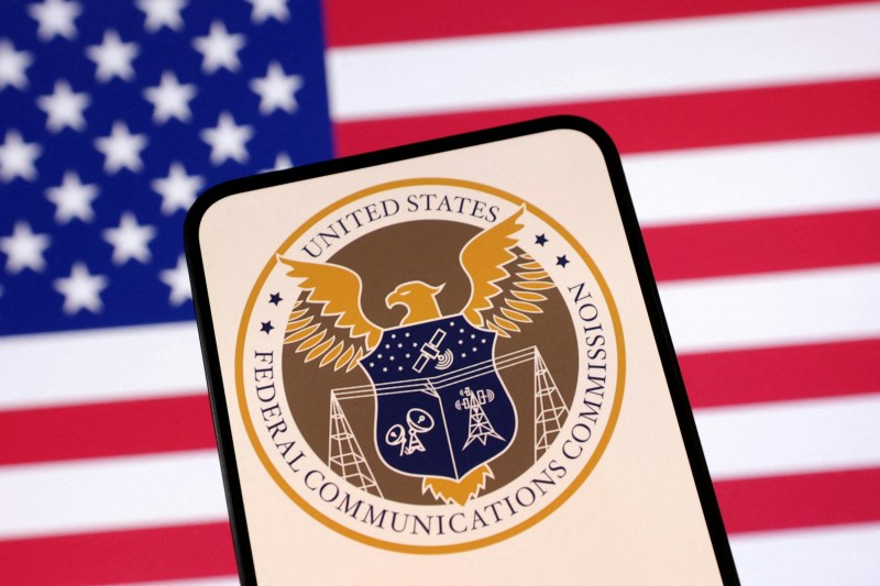 此插图于2025年4月23日绘制,显示美国联邦通讯委员会(FCC)标志与美国国旗。