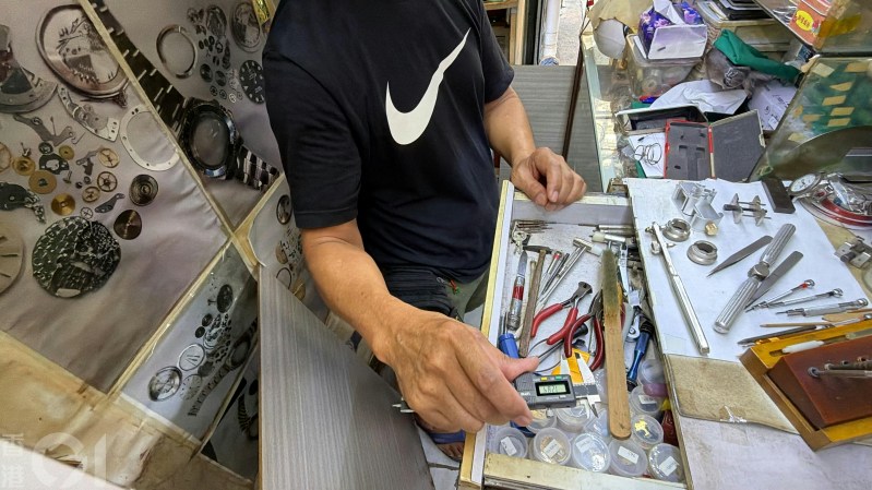 柯先生的工作台上,放满放大镜、螺丝批、钳子、游标卡尺及校表机等专业工具;亦有专门开劳力士表盖的钳。
