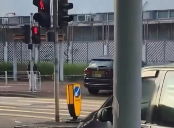 【连环图】网民拍摄到一辆挂有两地牌的私家车,在沙田乙明邨对开沙角街十字路口,突然在行人过路处剷上行人路,疑走捷径到另一方向,走回行车路入邨。期间旁边有数名行人等过马路,幸没有发生意外。(网片截图)