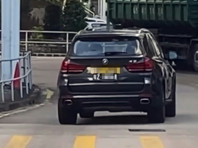 【连环图】网民拍摄到一辆挂有两地牌的私家车,在沙田乙明邨对开沙角街十字路口,突然在行人过路处剷上行人路,疑走捷径到另一方向,走回行车路入邨。期间旁边有数名行人等过马路,幸没有发生意外。(网片截图)