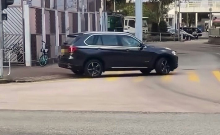 【连环图】网民拍摄到一辆挂有两地牌的私家车,在沙田乙明邨对开沙角街十字路口,突然在行人过路处剷上行人路,疑走捷径到另一方向,走回行车路入邨。期间旁边有数名行人等过马路,幸没有发生意外。(网片截图)