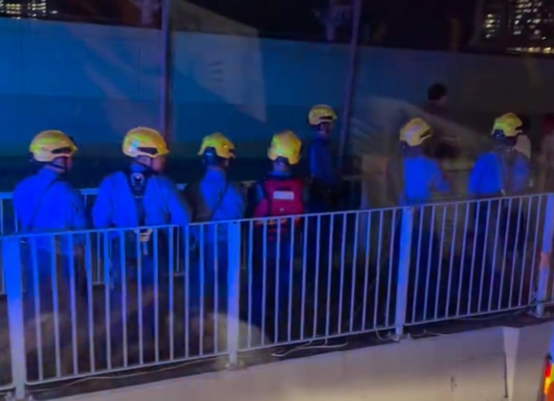 一名男子危坐于鸭脷洲大桥一个电箱上,大批消防员在场戒备。(FB 车cam L(香港群组)影片截图)