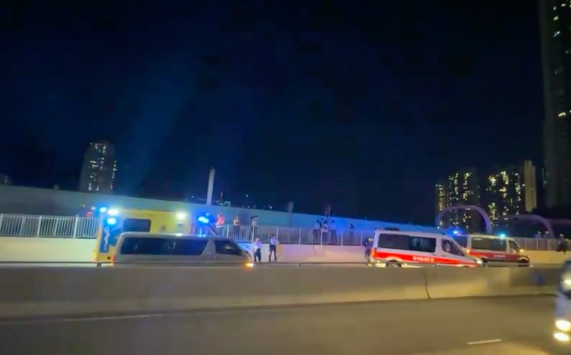 一名男子危坐于鸭脷洲大桥一个电箱上,大批消防员在场戒备。
