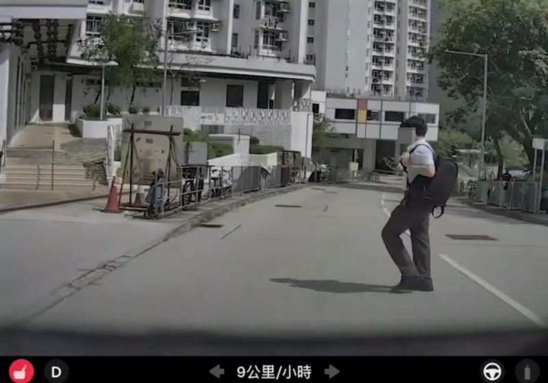 画面清楚可见,该名男生右手持着一部智能电话,双眼一直盯着手机,由踏出马路至行至片主车头中央,全程未曾抬头张望两旁路面状况。