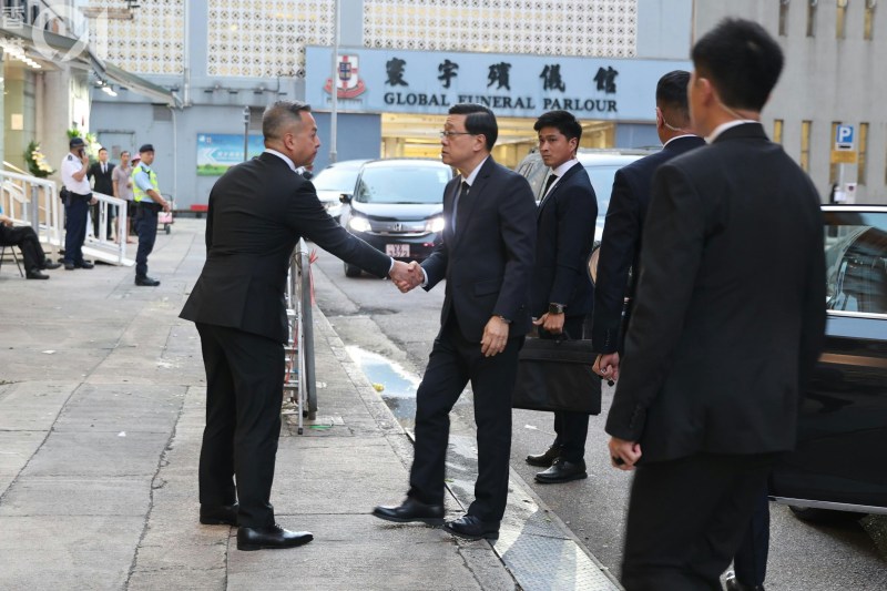 行政长官李家超到达灵堂吊唁,周一鸣在殡仪馆外迎接。