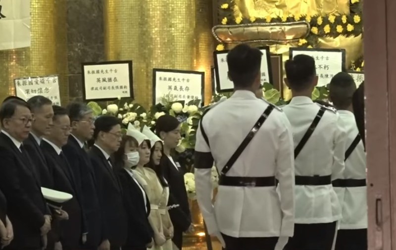 丧礼官方仪式正式开始,灵堂内家属及一众来宾起立。