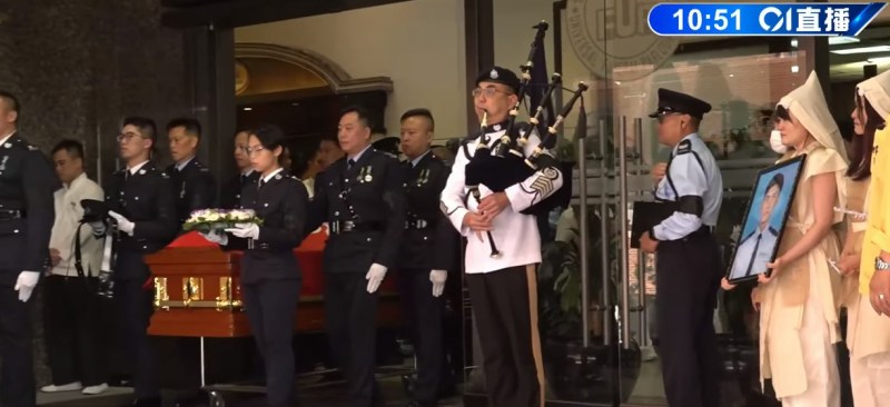 丧礼仪式完毕,扶灵队伍护送灵柩离开灵堂,盖上区旗的灵柩被抬上灵车。