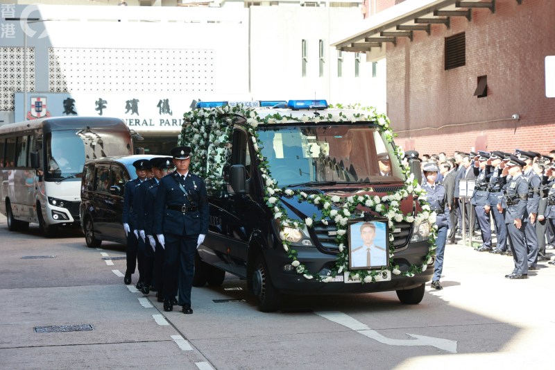 灵车驶离殡仪馆,政府官员及一众警方代表在殡仪馆外列队,向朱振国作最后致敬。