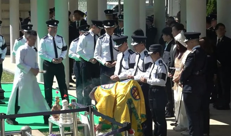 警队同袍轮流在墓前上香拜祭。