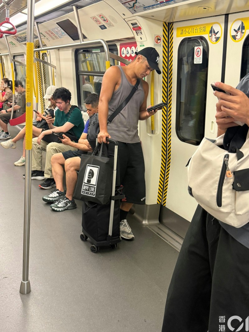 《香港01》讀者直擊前港男冠軍翟威廉現身港鐵站,毫無包袱親自拉手推車送貨。
