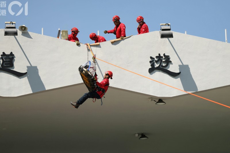 现场有民安队成员示范山岭空中搜救技术。