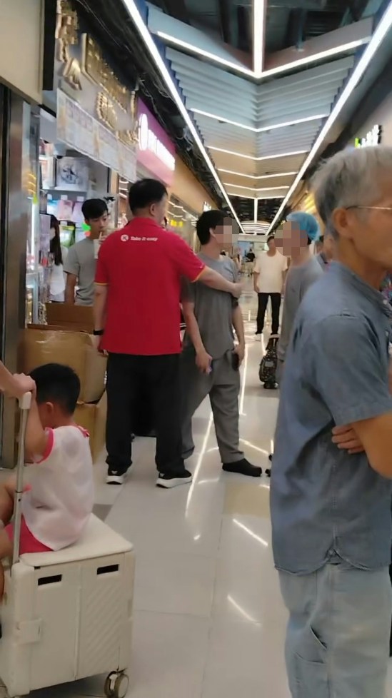 二人拉扯期间，有与灰衣男穿着相同制服的同事上前了解，一度离去后又折返。