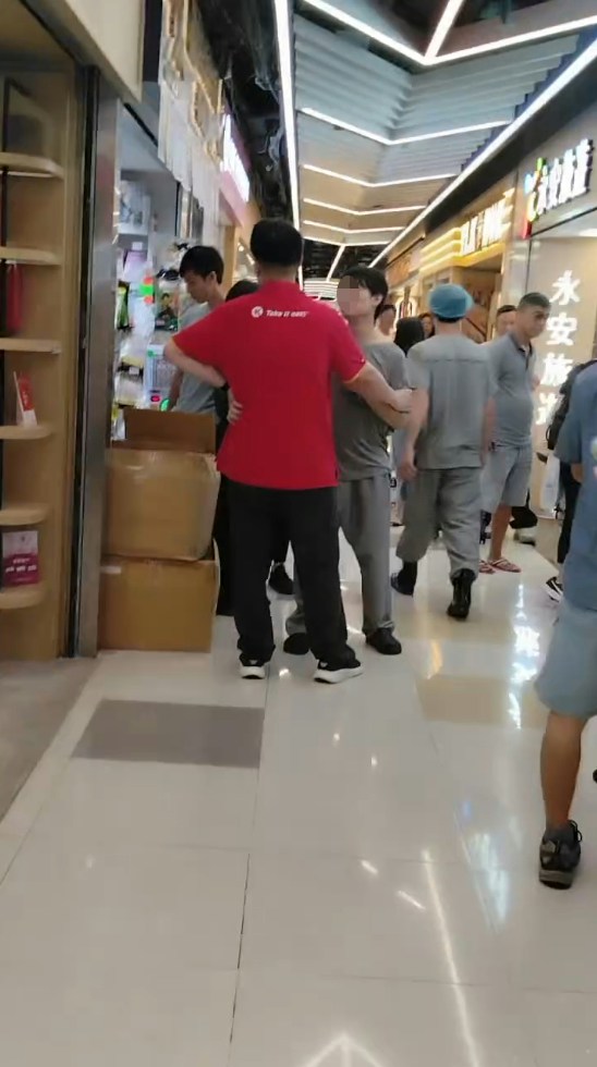 二人拉扯期间，有与灰衣男穿着相同制服的同事上前了解，一度离去后又折返。