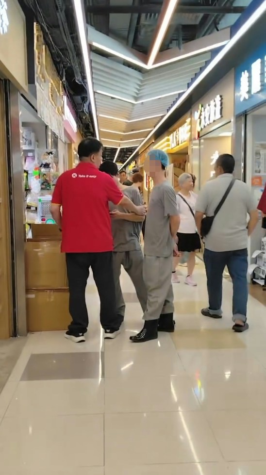 二人拉扯期间，有与灰衣男穿着相同制服的同事上前了解，一度离去后又折返。